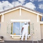 Exterior house painting in progress with fresh cream trim.