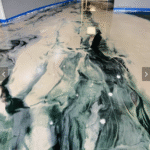 Residential kitchen floor with decorative epoxy coating in a marbled pattern.